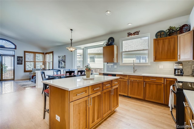 9451 Desert Willow Trl, Highlands Ranch, CO 80129 - kitchen with black electric range oven, a sink, light wood finished floors, light countertops, and a breakfast bar