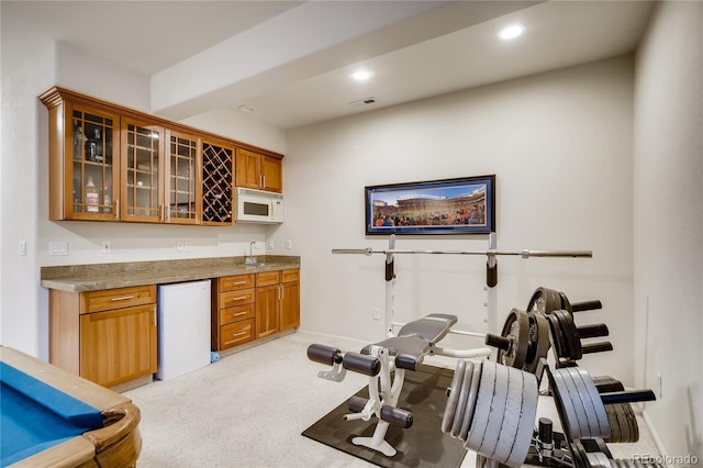 9451 Desert Willow Trl, Highlands Ranch, CO 80129 - indoor wet bar with refrigerator, white microwave, light colored carpet, recessed lighting, and baseboards