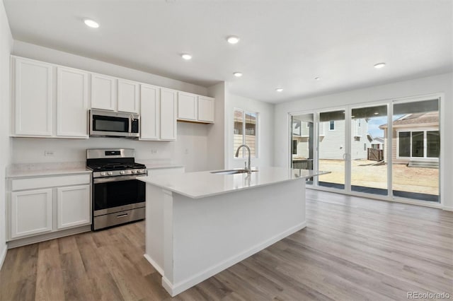 9672 Cathay St, Commerce City, CO 80022 - kitchen featuring white cabinets, light countertops, a sink, light wood-style flooring, and appliances with stainless steel finishes