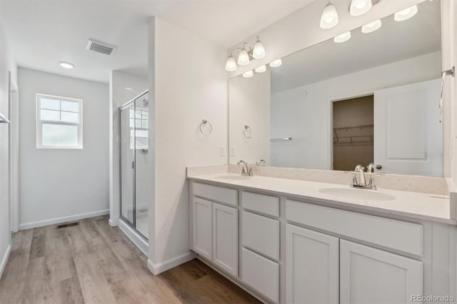 9672 Cathay St, Commerce City, CO 80022 - full bath featuring wood finished floors, a sink, visible vents, and a stall shower