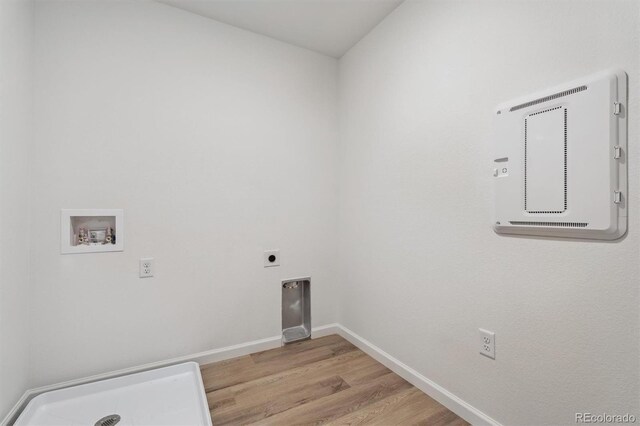9672 Cathay St, Commerce City, CO 80022 - clothes washing area featuring light wood finished floors, hookup for an electric dryer, baseboards, hookup for a washing machine, and laundry area