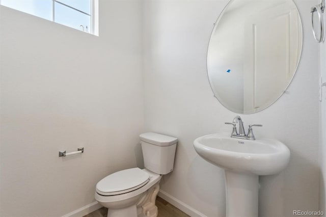 9672 Cathay St, Commerce City, CO 80022 - half bathroom featuring wood finished floors, baseboards, a sink, and toilet