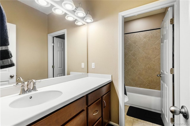 full bathroom featuring vanity, tile patterned floors, toilet, and tiled shower / bath