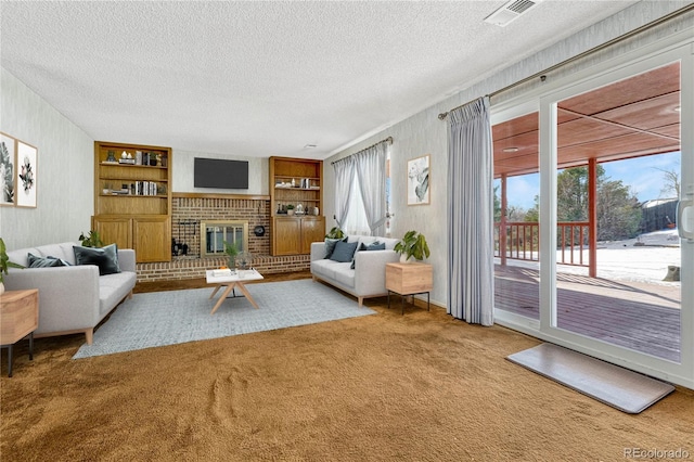 living room with a fireplace, built in features, a textured ceiling, and carpet flooring