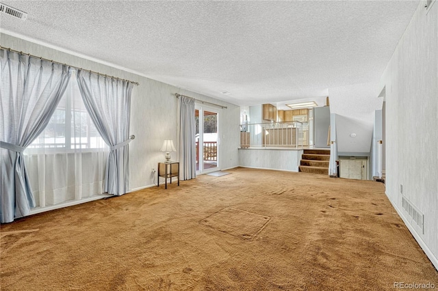 unfurnished living room featuring carpet floors and a textured ceiling