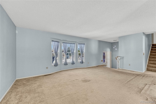 unfurnished room featuring carpet floors and a textured ceiling