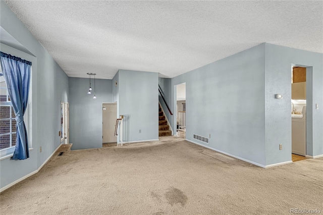 carpeted spare room featuring a textured ceiling