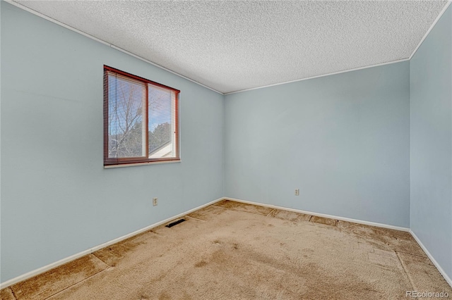 carpeted empty room featuring a textured ceiling