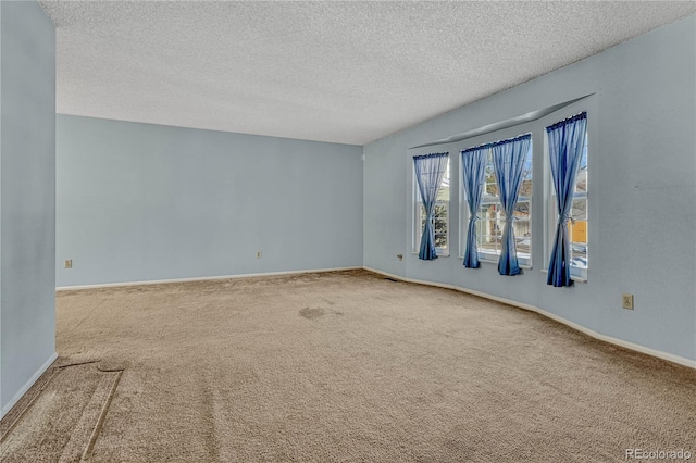 carpeted empty room with a textured ceiling