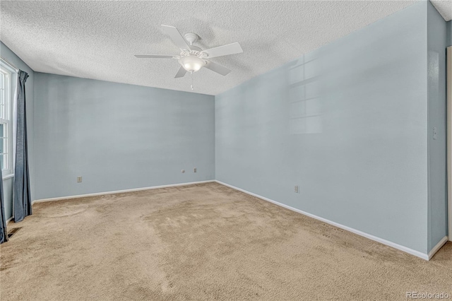 carpeted empty room with ceiling fan and a textured ceiling