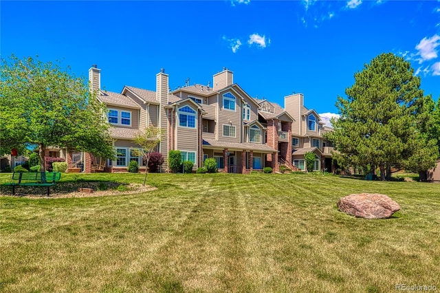 4760 S Wadsworth Blvd Unit 302, Littleton, CO 80123 - rear view of house featuring a lawn and brick siding