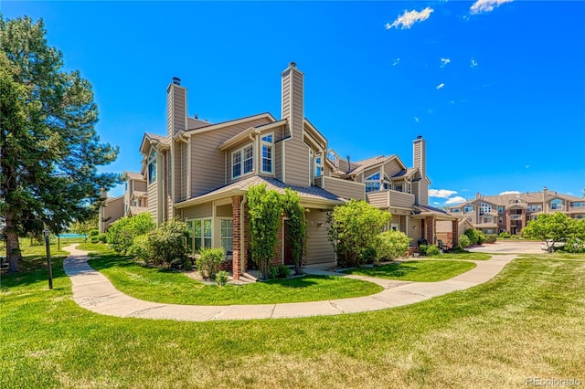 4760 S Wadsworth Blvd Unit 302, Littleton, CO 80123 - back of property with a yard, brick siding, and a chimney