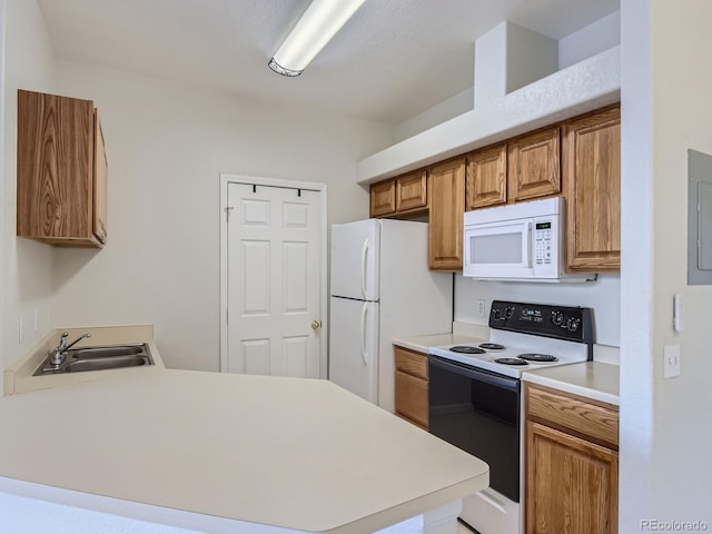 kitchen with kitchen peninsula, white appliances, and sink