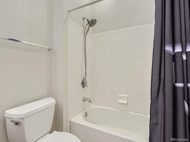 bathroom featuring shower / bathtub combination with curtain and toilet