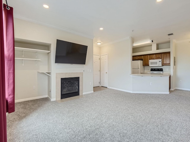 unfurnished living room with ornamental molding, light carpet, and a tiled fireplace