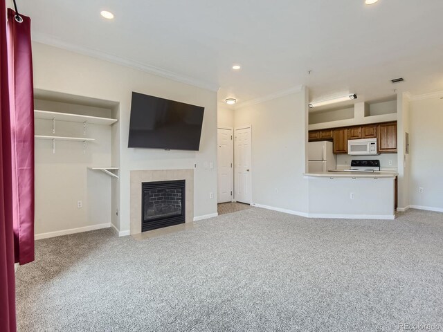 unfurnished living room with light carpet, baseboards, a tile fireplace, and crown molding