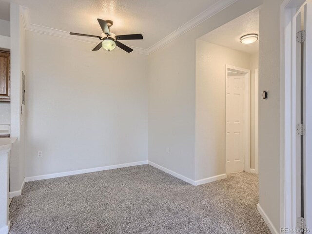 unfurnished room featuring a ceiling fan, light colored carpet, crown molding, and baseboards