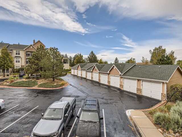 view of front of property with stone siding, a residential view, and community garages