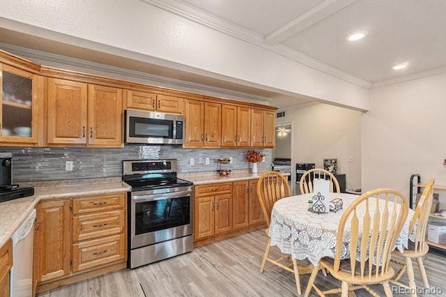 4545 Raritan St, Denver, CO 80211 - kitchen featuring stainless steel appliances, light wood-type flooring, tasteful backsplash, light countertops, and crown molding