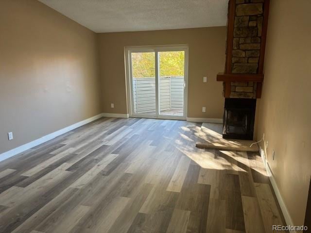 unfurnished living room featuring a textured ceiling, a fireplace, and hardwood / wood-style flooring