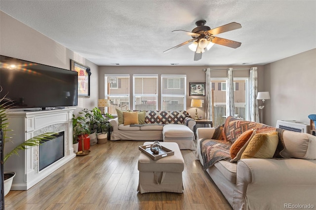 11062 Gaylord St, Northglenn, CO 80233 - living room featuring a ceiling fan, wood finished floors, a textured ceiling, and a high end fireplace