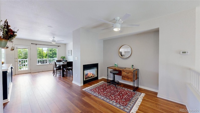 2560 Concord Cir, Lafayette, CO 80026 - interior space featuring a multi sided fireplace, a ceiling fan, and wood finished floors