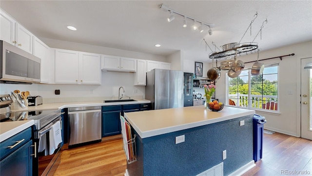 2560 Concord Cir, Lafayette, CO 80026 - kitchen featuring appliances with stainless steel finishes, blue cabinets, white cabinets, light countertops, and recessed lighting