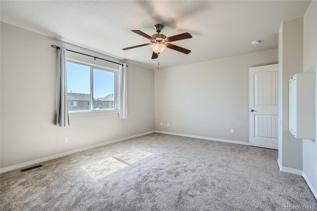 carpeted spare room featuring ceiling fan