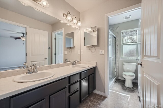 bathroom with walk in shower, dual bowl vanity, toilet, ceiling fan, and tile patterned floors