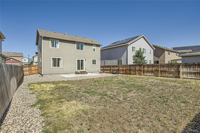 back of property featuring solar panels, a yard, and a patio area