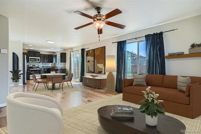 living room featuring light wood-type flooring and ceiling fan