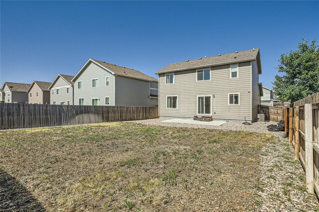 rear view of house with a patio and a yard