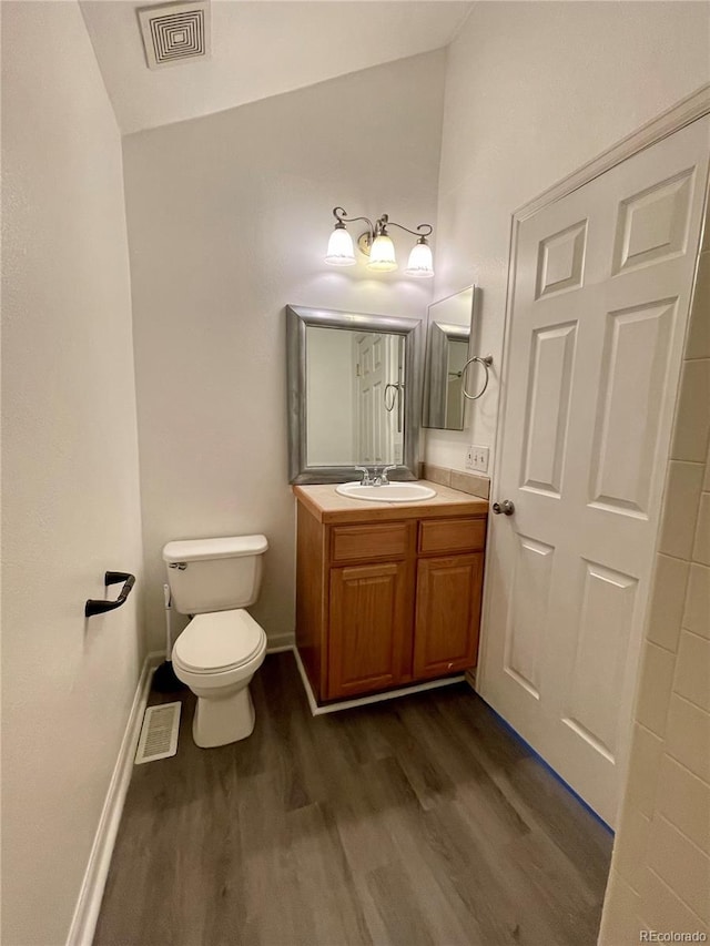 bathroom featuring vanity, hardwood / wood-style flooring, and toilet