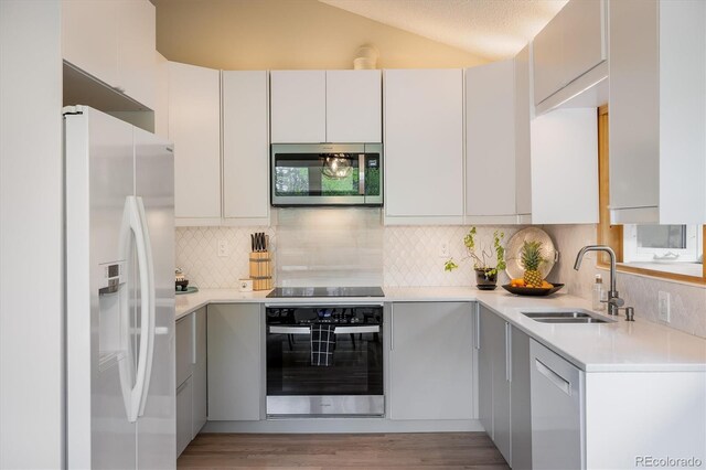 1194 Camp Eden Rd, Golden, CO 80403 - kitchen with stainless steel appliances, a sink, light countertops, backsplash, and lofted ceiling