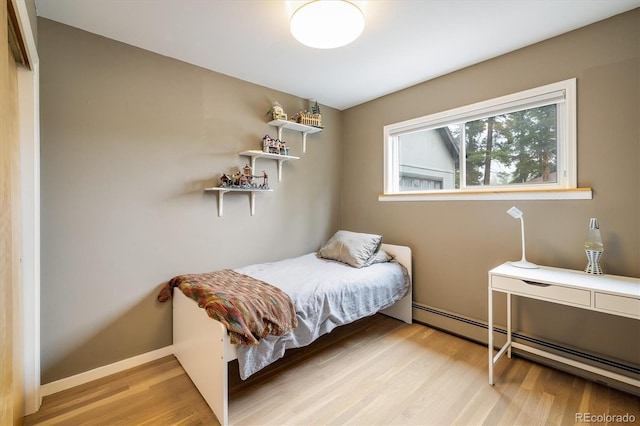 1194 Camp Eden Rd, Golden, CO 80403 - bedroom with a baseboard heating unit and light wood-style flooring