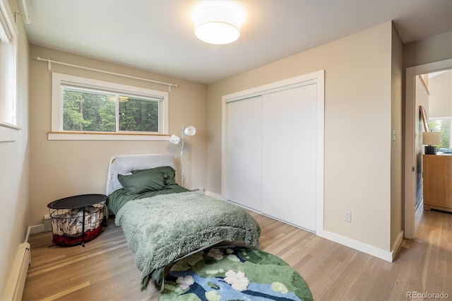 1194 Camp Eden Rd, Golden, CO 80403 - bedroom with wood finished floors, a closet, a baseboard heating unit, and baseboards