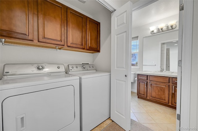 laundry room with washer and clothes dryer, cabinet space, a sink, and light tile patterned floors