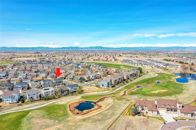 drone / aerial view with a water and mountain view, view of golf course, and a residential view