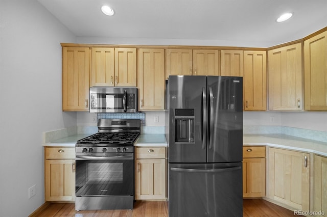 32501 E 137th Way, Brighton, CO 80603 - kitchen with stainless steel appliances, light brown cabinetry, light countertops, light wood-style floors, and recessed lighting