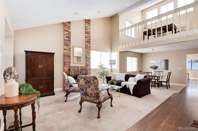 living room featuring light hardwood / wood-style floors, a fireplace, and high vaulted ceiling