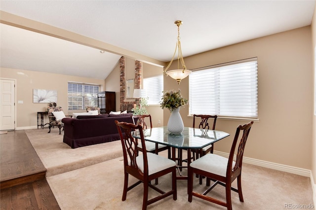 dining space with hardwood / wood-style floors and vaulted ceiling