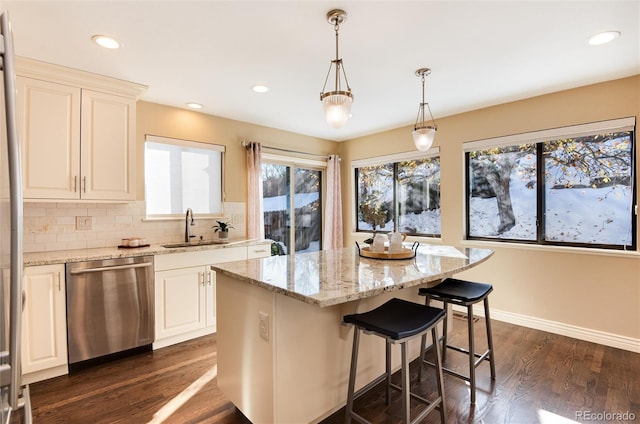 kitchen featuring dark hardwood / wood-style flooring, dishwasher, a kitchen island, and sink