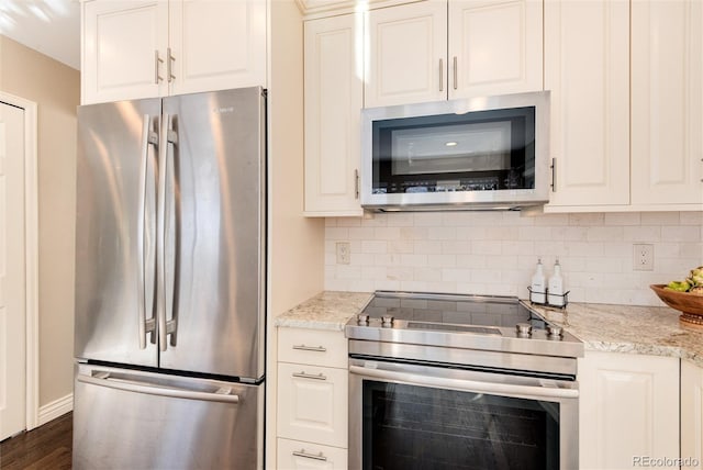 kitchen with backsplash, dark wood-type flooring, white cabinets, light stone countertops, and appliances with stainless steel finishes