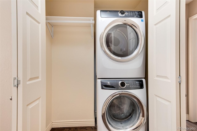 laundry area with stacked washer and dryer and dark hardwood / wood-style floors