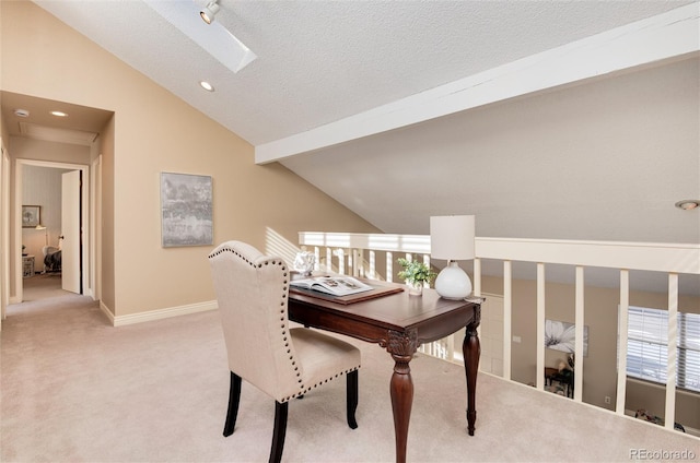 carpeted office space with lofted ceiling with skylight and a textured ceiling