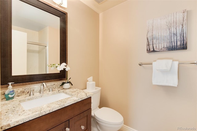 bathroom featuring vanity, toilet, and a shower with door