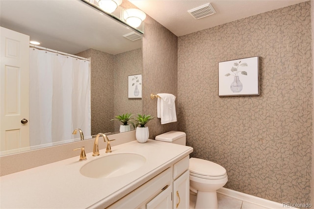 bathroom with tile patterned flooring, vanity, and toilet