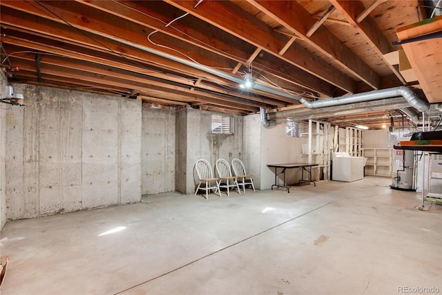 basement featuring water heater and washer / dryer