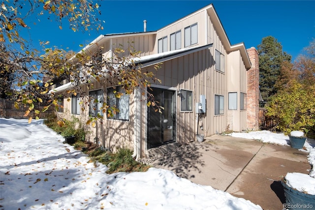 snow covered property with a patio area