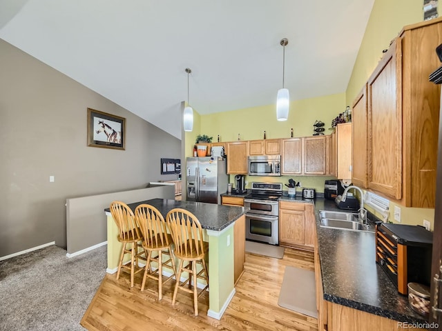 kitchen with a center island, a kitchen breakfast bar, light hardwood / wood-style floors, stainless steel appliances, and pendant lighting